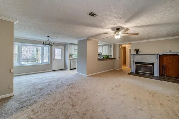 an empty room with windows and fireplace