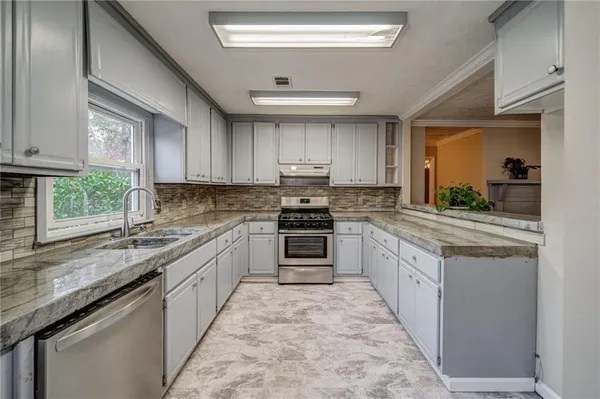 a kitchen with stainless steel appliances granite countertop a stove and a sink