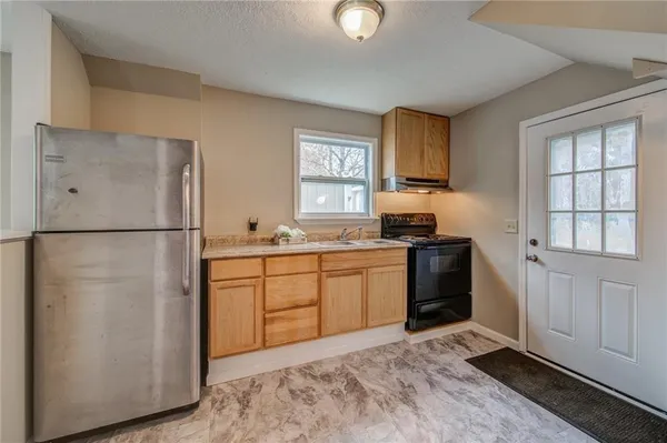 a kitchen with stainless steel appliances granite countertop a refrigerator sink and cabinets