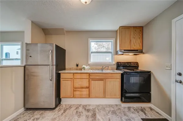 a kitchen with stainless steel appliances granite countertop a refrigerator stove a sink and a oven