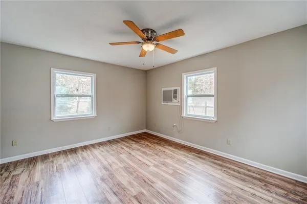 a view of a room with window ceiling fan and wooden floor