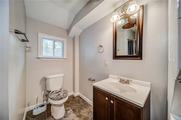 a bathroom with a toilet sink and mirror