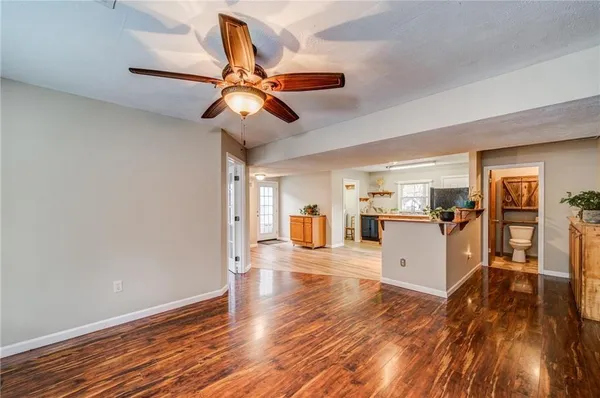 a view of a living room and kitchen with wooden floor
