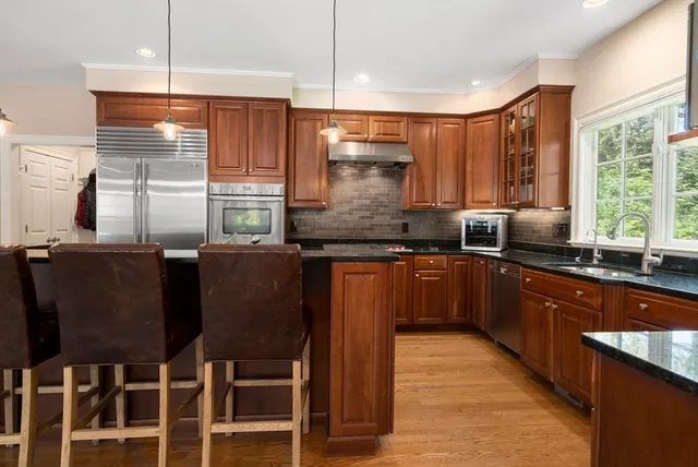 a kitchen with granite countertop a sink counter top space and stainless steel appliances