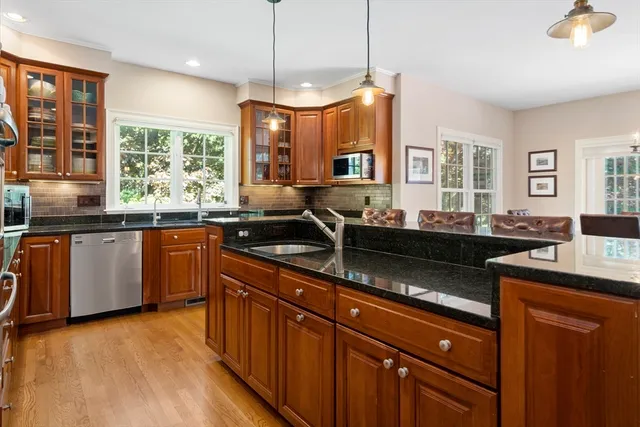 a kitchen with granite countertop a sink and wooden cabinets