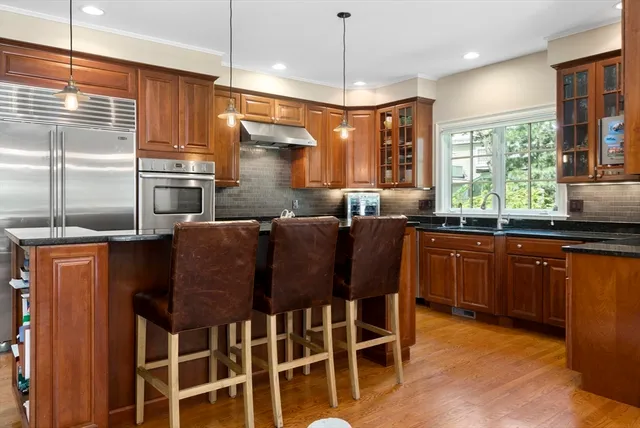 a kitchen with granite countertop wooden cabinets dining table and chairs