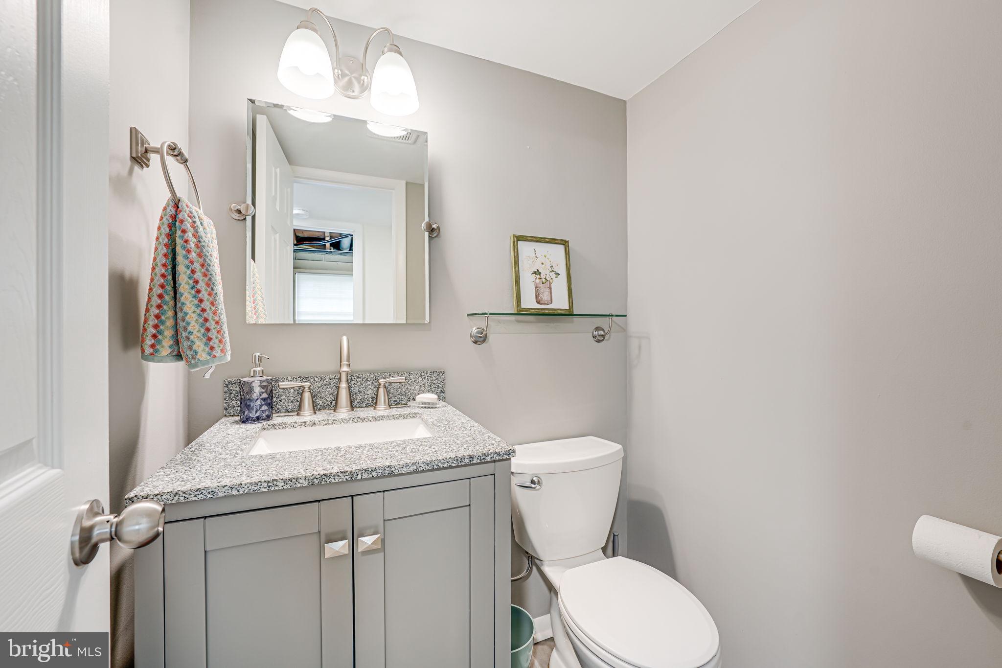 8315 Greeley Boulevard Springfield, VA 22152 - Photo 30 of 44 a bathroom with a granite countertop toilet sink and mirror