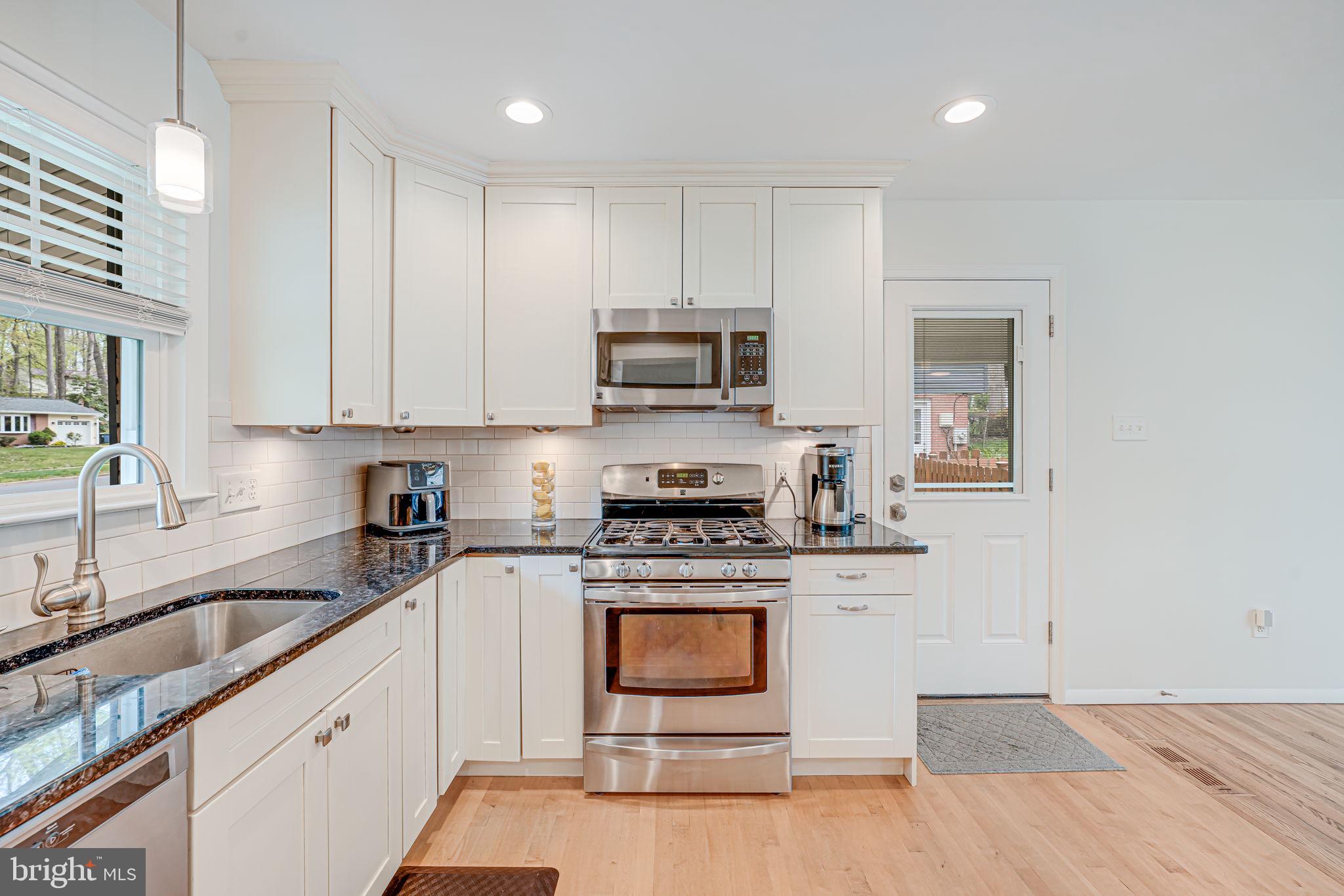 8315 Greeley Boulevard Springfield, VA 22152 - Photo 3 of 44 a kitchen with granite countertop a stove a sink and a microwave