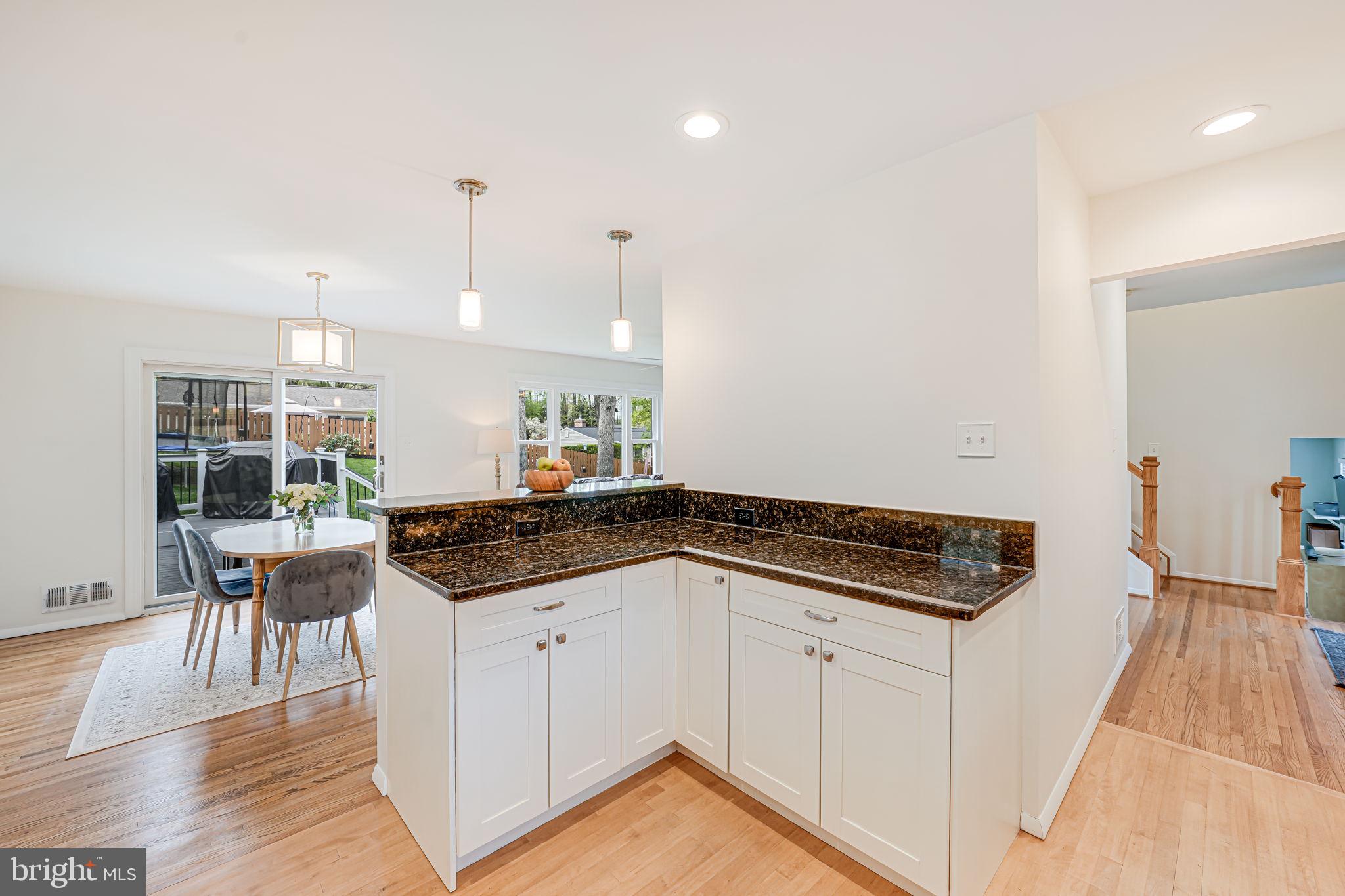 8315 Greeley Boulevard Springfield, VA 22152 - Photo 5 of 44 a kitchen with granite countertop a stove and white cabinets