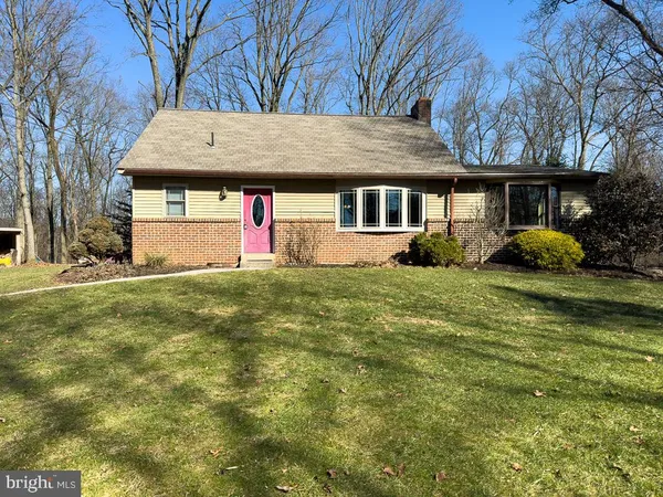 a front view of house with yard and trees in the background