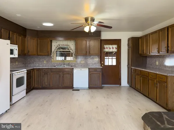 a kitchen with stainless steel appliances granite countertop a stove granite counter tops and white cabinets