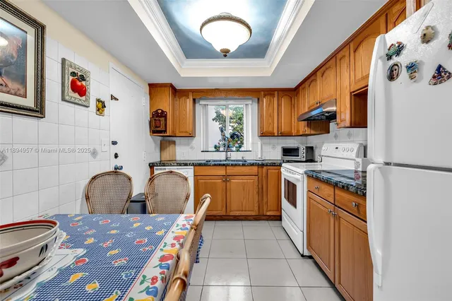 a kitchen with stainless steel appliances granite countertop a sink and a refrigerator