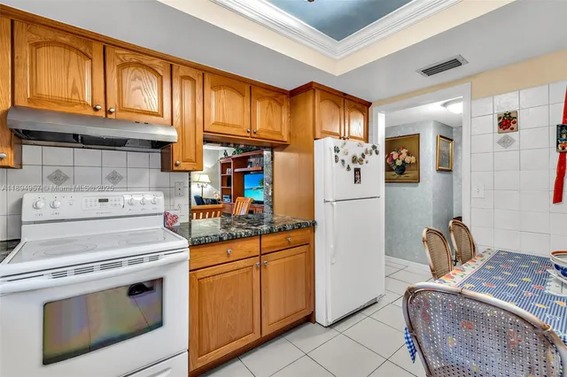 a kitchen with stainless steel appliances granite countertop a refrigerator sink and stove