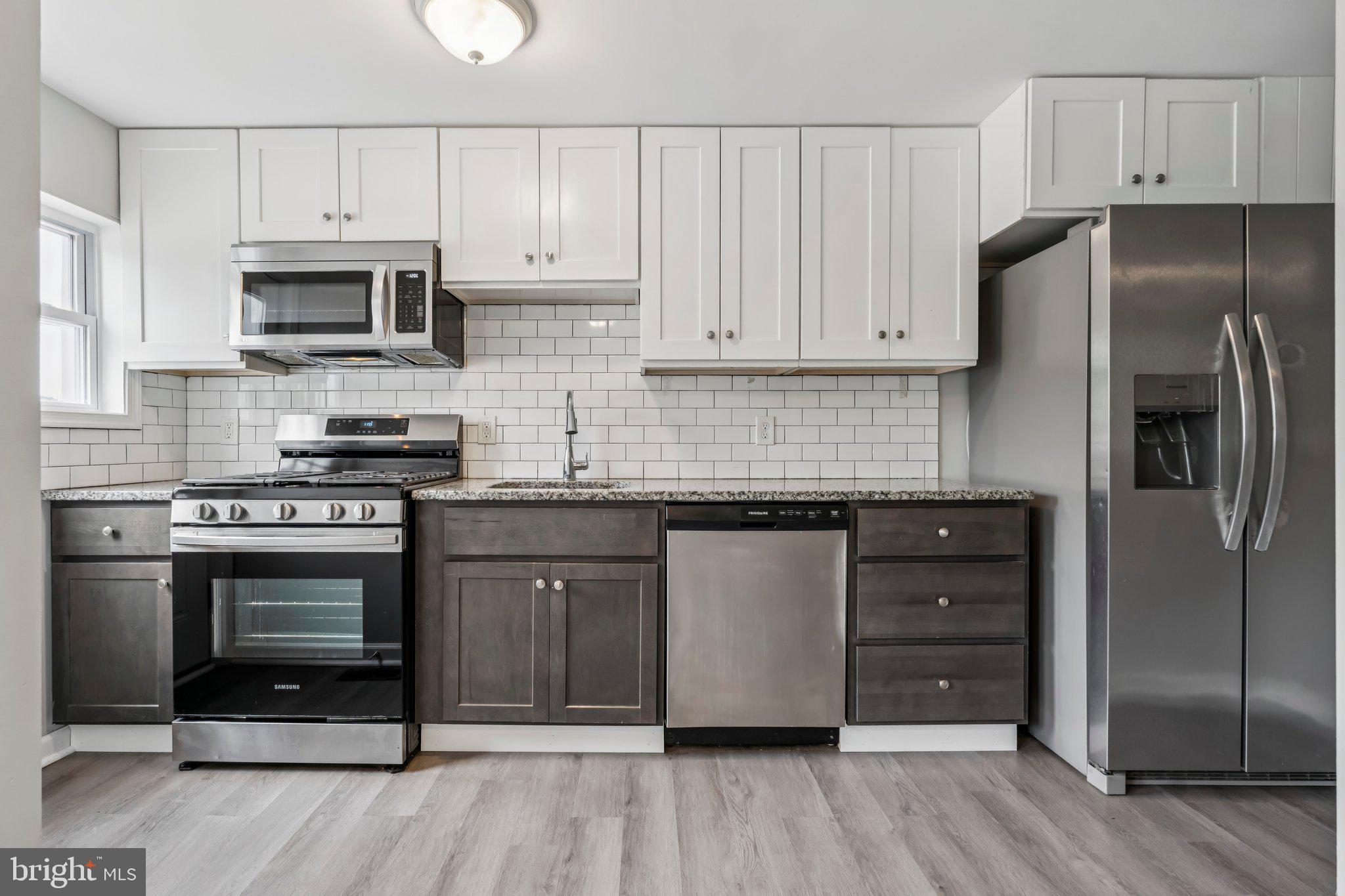 7838 St Boniface Lane Dundalk, MD 21222 - Photo 12 of 37 a kitchen with stainless steel appliances granite countertop a stove a refrigerator and a microwave