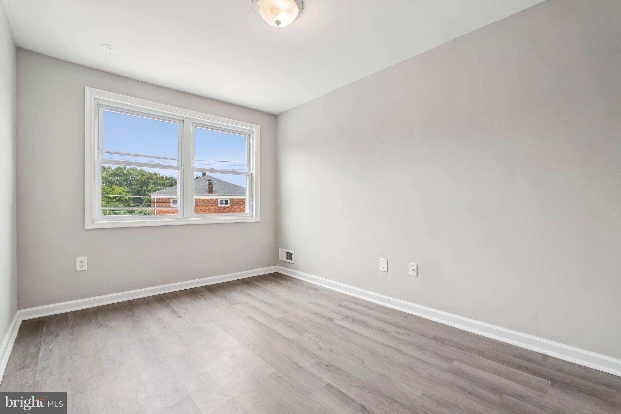 7838 St Boniface Lane Dundalk, MD 21222 - Photo 16 of 37 an empty room with wooden floor and windows