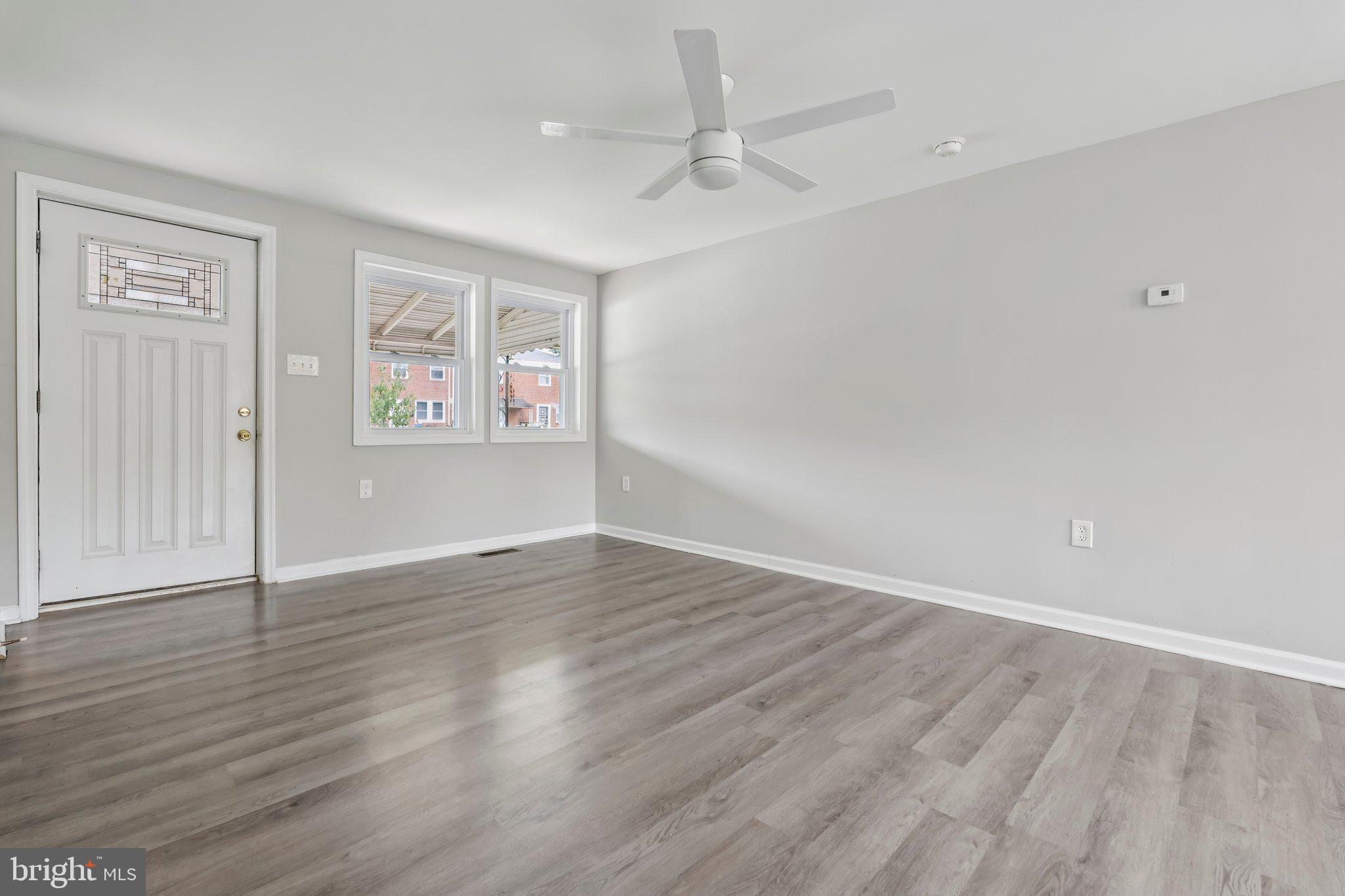 7838 St Boniface Lane Dundalk, MD 21222 - Photo 4 of 37 an empty room with wooden floor ceiling fan and windows