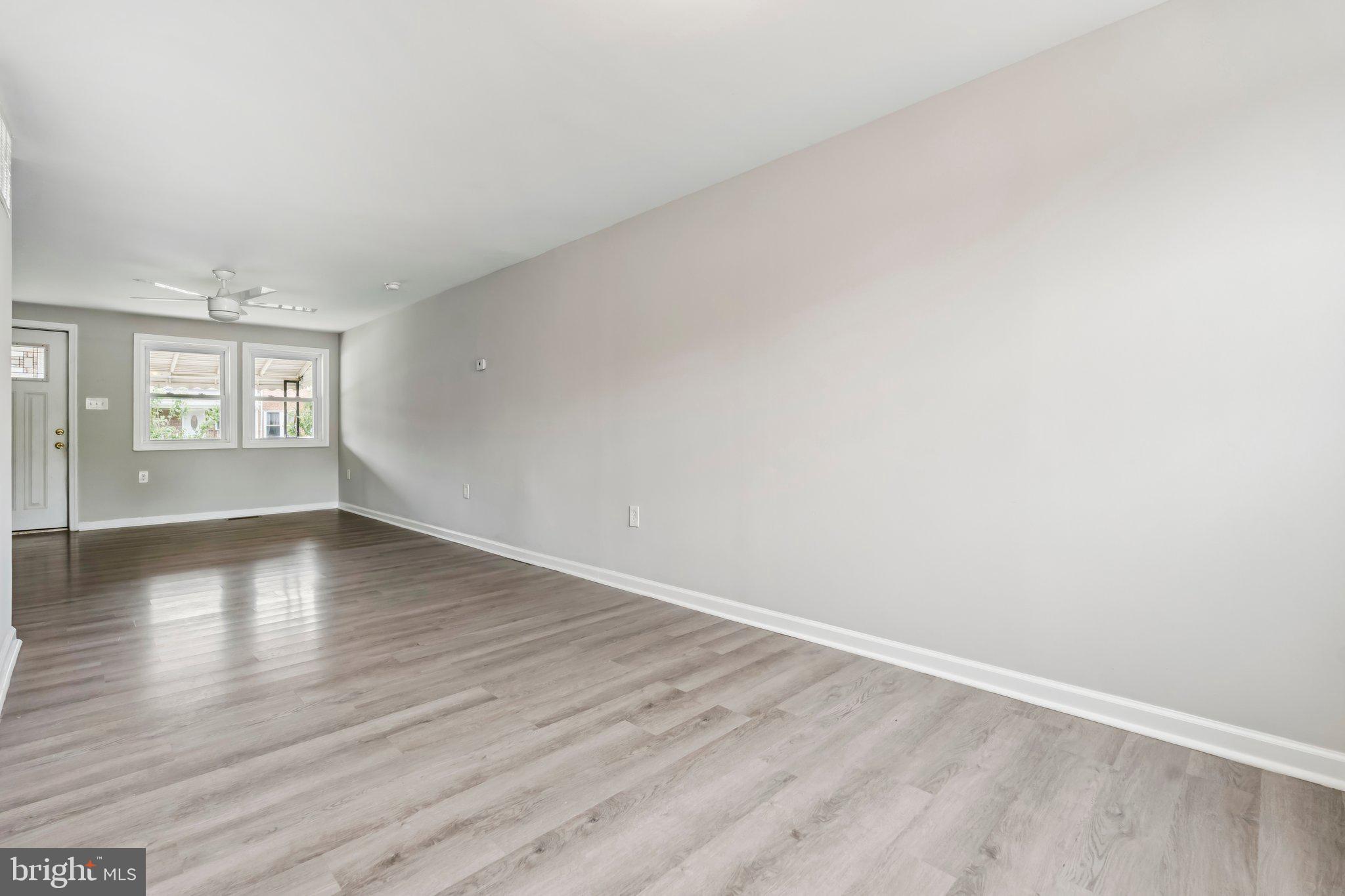 7838 St Boniface Lane Dundalk, MD 21222 - Photo 8 of 37 an empty room with wooden floor and windows