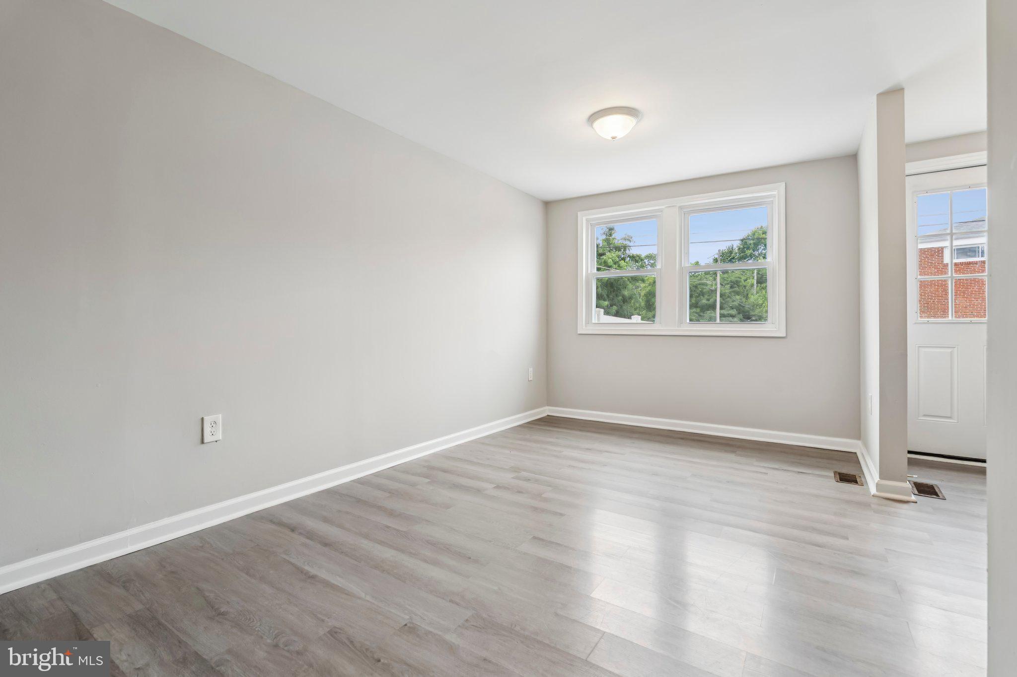 7838 St Boniface Lane Dundalk, MD 21222 - Photo 9 of 37 an empty room with wooden floor and windows