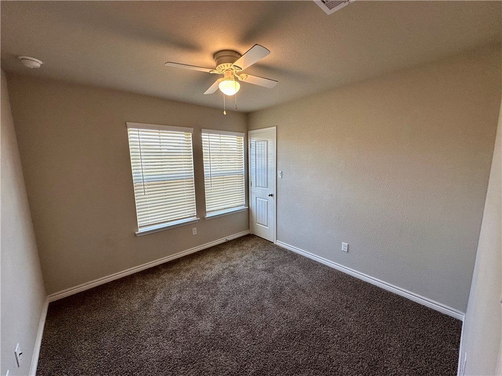 2110 Chief Street Bryan, TX 77807 - Photo 9 of 16 Carpeted spare room featuring a ceiling fan and baseboards