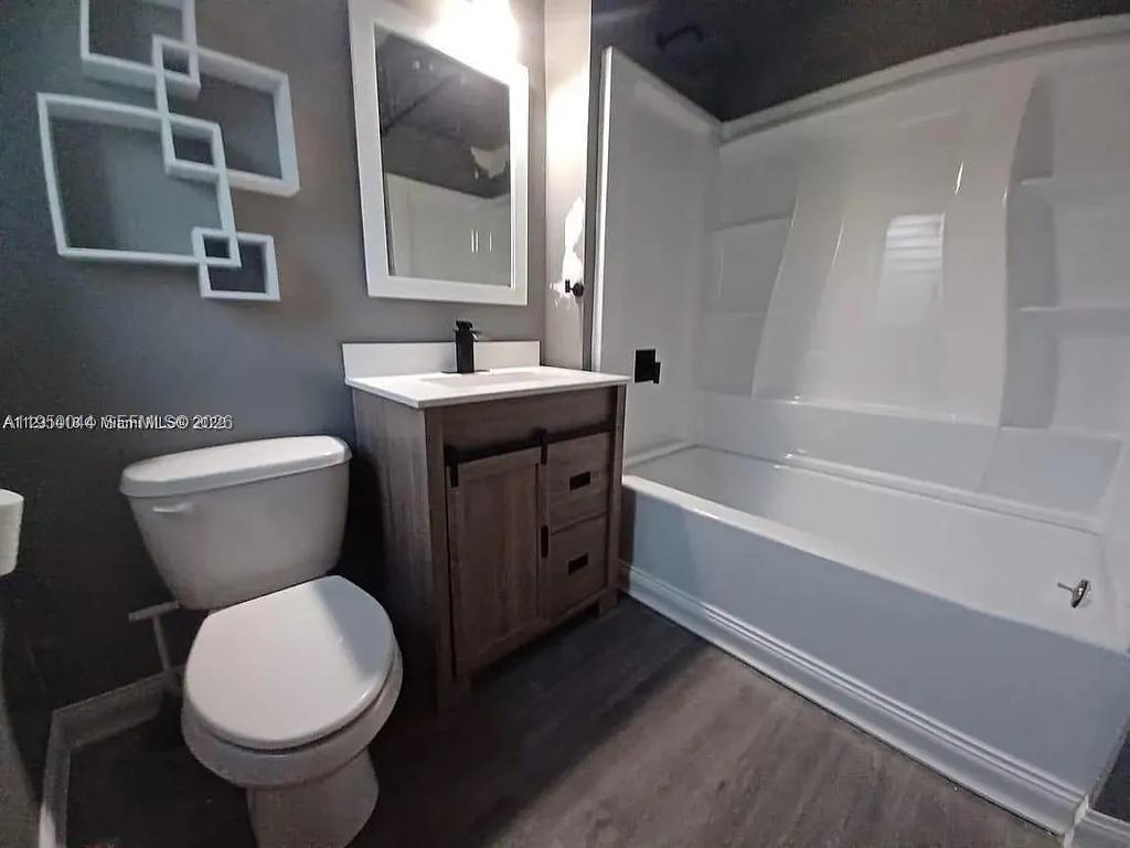 2822 Pine Tree Drive, Unit 4A Miami Beach, FL 33140 - Photo 11 of 13 a bathroom with a toilet sink and mirror