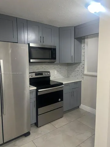 a kitchen with cabinets stainless steel appliances and a counter space