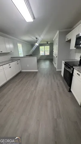 a view of a kitchen with a sink and dishwasher stove top oven with wooden floor