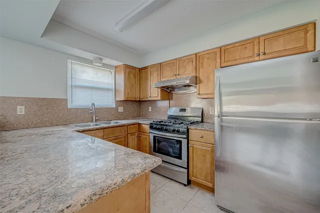 a kitchen with stainless steel appliances granite countertop a sink and a stove