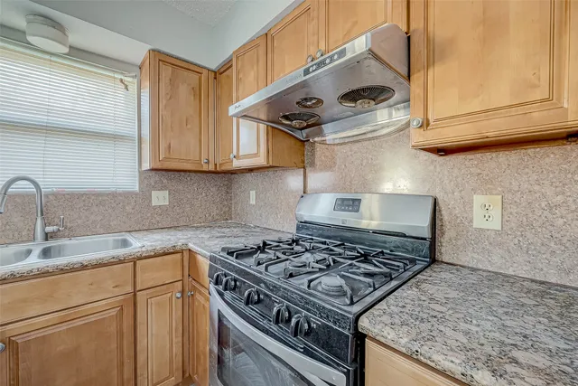 a kitchen with stainless steel appliances granite countertop a stove and a sink