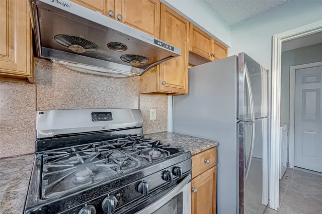 a stove top oven sitting inside of a kitchen