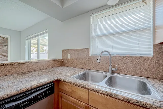 a kitchen with granite countertop a sink and a window