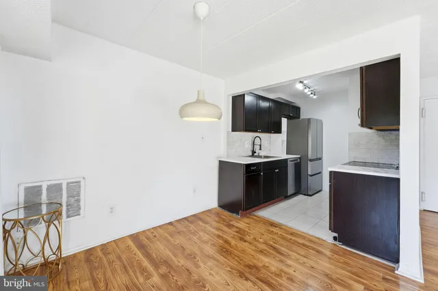 a large kitchen with a sink and dishwasher a stove top oven with wooden floor