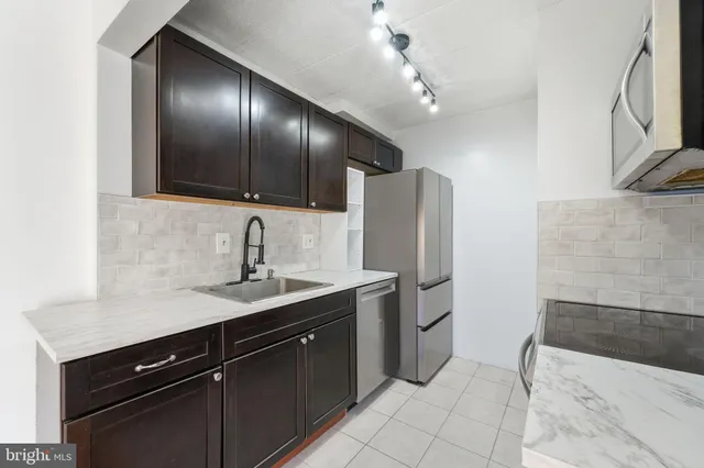 a kitchen with a sink refrigerator and cabinets