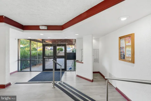 a living room with a floor to ceiling window and a rug