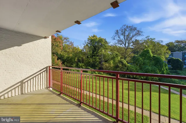 a view of a balcony with wooden floor and a floor to ceiling window