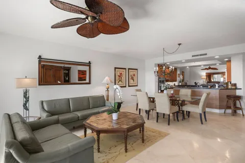 a living room with furniture kitchen view and a chandelier