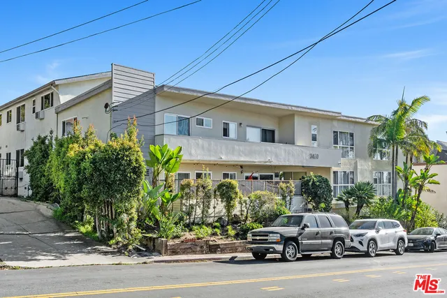 a couple of cars parked in front of a house