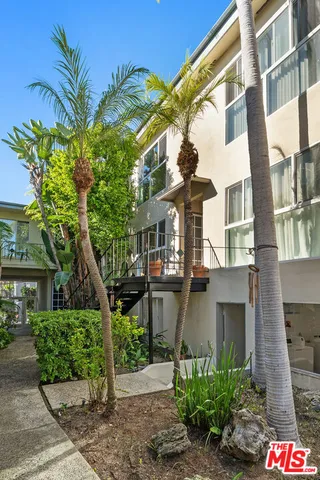 a front view of a house with a large tree