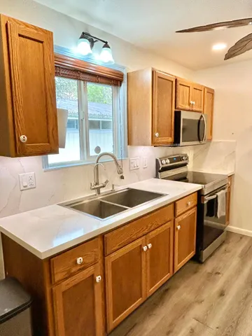 a kitchen with stainless steel appliances granite countertop a sink and a stove