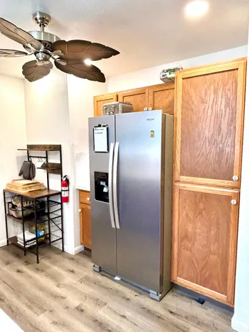 a kitchen view of a refrigerator and cabinets