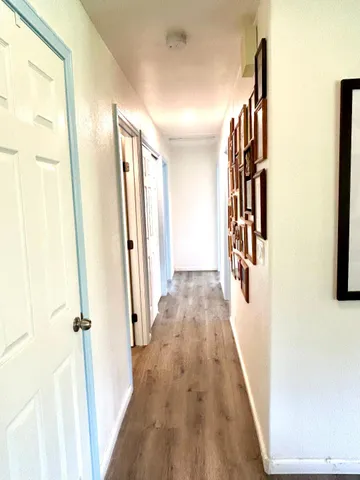 a view of a hallway with wooden floor and staircase