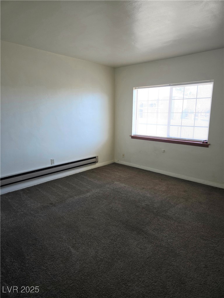 633 Nevada Way, Unit 3 Boulder City, NV 89005 - Photo 3 of 7 Unfurnished room with dark colored carpet and baseboard heating