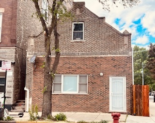 front view of a brick house with a small yard
