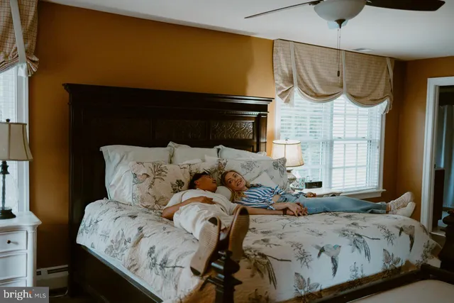 a bedroom with a bed chair and a window
