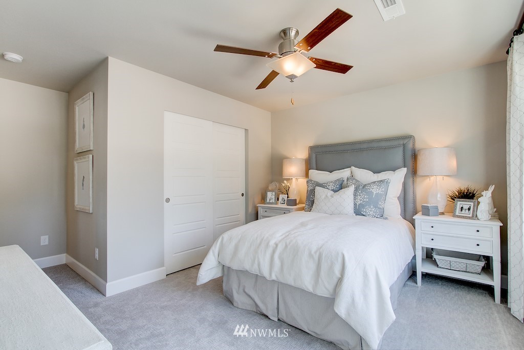 9779 Prospect Place Gig Harbor, WA 98332 - Photo 17 of 22 a bedroom with a bed and a chandelier
