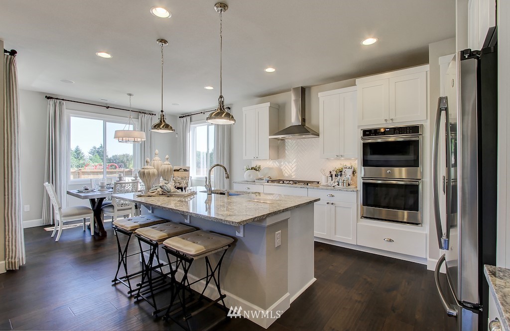 9779 Prospect Place Gig Harbor, WA 98332 - Photo 5 of 22 a kitchen with a table chairs refrigerator and cabinets