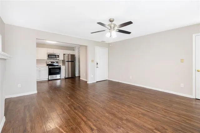 a view of a livingroom with wooden floor and a ceiling fan