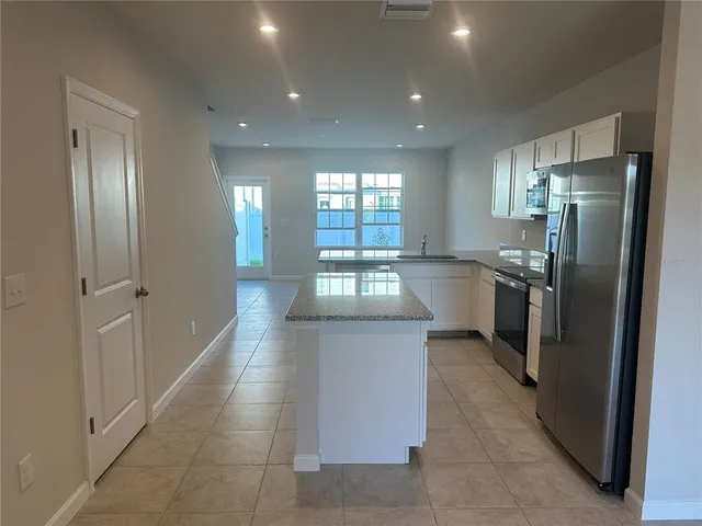 a kitchen with stainless steel appliances granite countertop a refrigerator and a sink