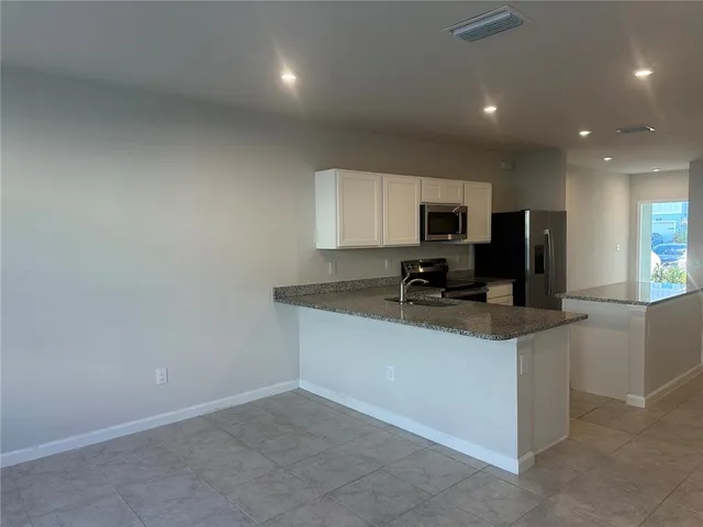 a kitchen with a sink a stove a microwave and a refrigerator