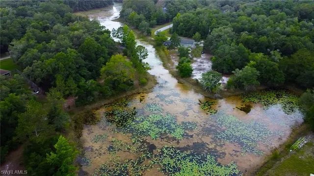 an aerial view of residential house with outdoor space and trees all around