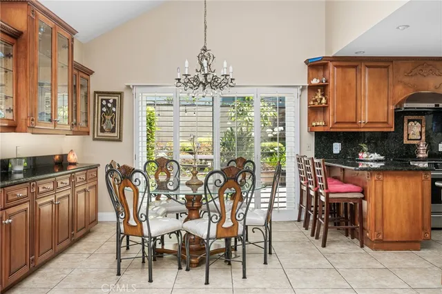 a kitchen with sink refrigerator dining table and chairs